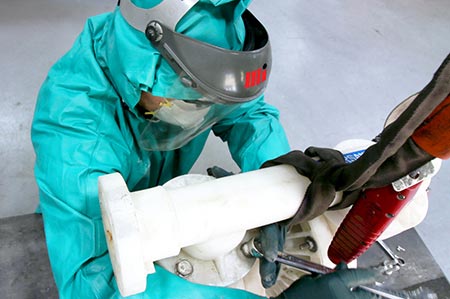 工人在PPE拆卸一个气动doule-diaphram (AODD)泵注入盐酸