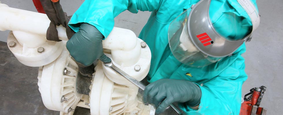 工人在PPE拆卸一个气动双膜片(AODD)盐酸。